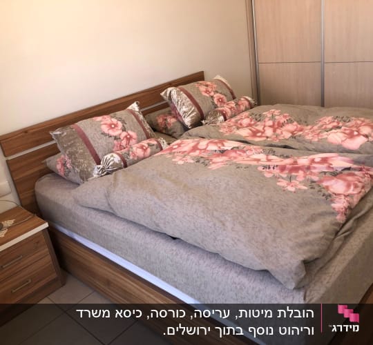 מיטה עם מצעים פרחוניים בחדר שינה